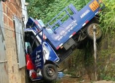 Imagem de Caminhão fica 'pendurado' entre casa e ribanceira após acidente em Itabuna
